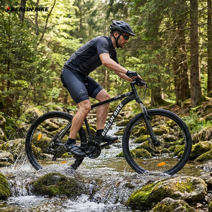 Mountainbike-Fahrer auf einem 29 Zoll Berlin Bike MTB durchquert einen Bach im Wald unter schwierigen Trail-Bedingungen